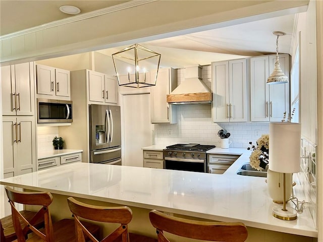 kitchen with appliances with stainless steel finishes, a kitchen breakfast bar, a peninsula, backsplash, and custom exhaust hood