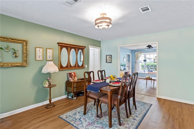 dining room featuring visible vents, baseboards, and wood finished floors