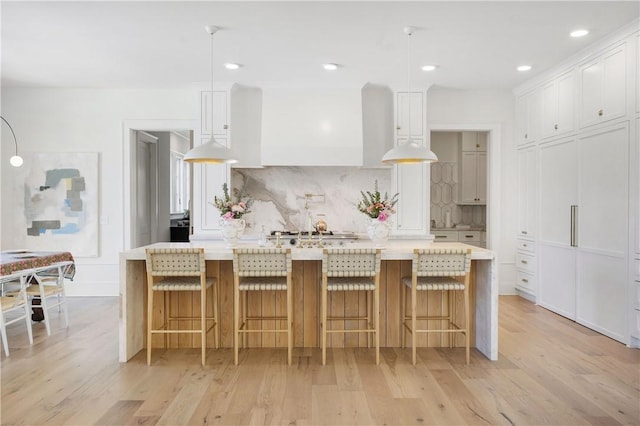 kitchen featuring light wood-type flooring, light countertops, and decorative backsplash