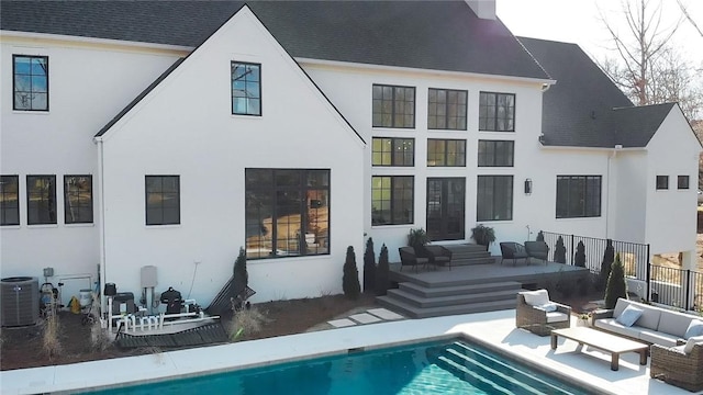 rear view of house with an outdoor hangout area, stucco siding, an outdoor pool, and central air condition unit