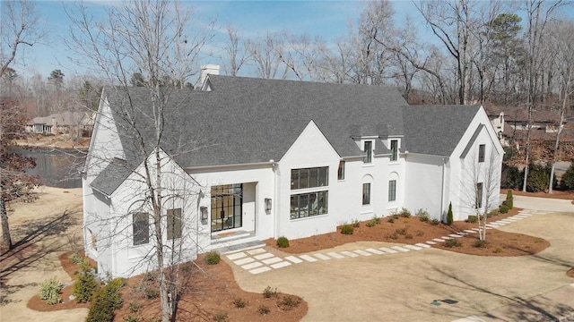 view of front of house featuring a chimney and stucco siding