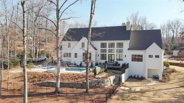 back of house with a chimney and stucco siding