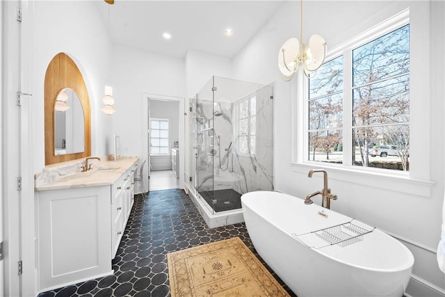 bathroom with a marble finish shower, recessed lighting, an inviting chandelier, vanity, and a freestanding tub