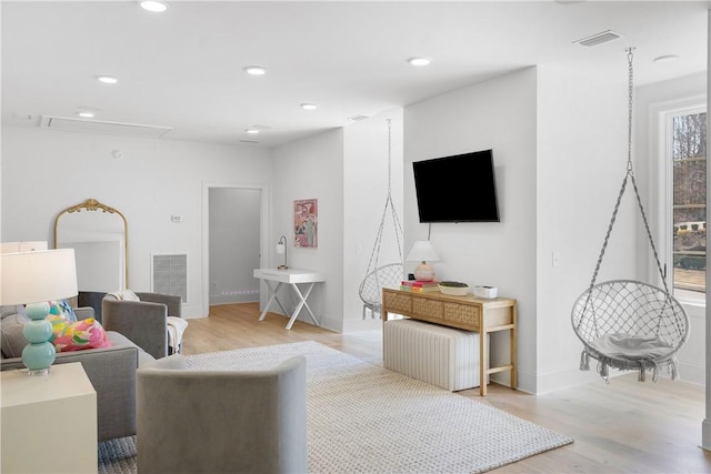 living room with light wood-type flooring, visible vents, and recessed lighting