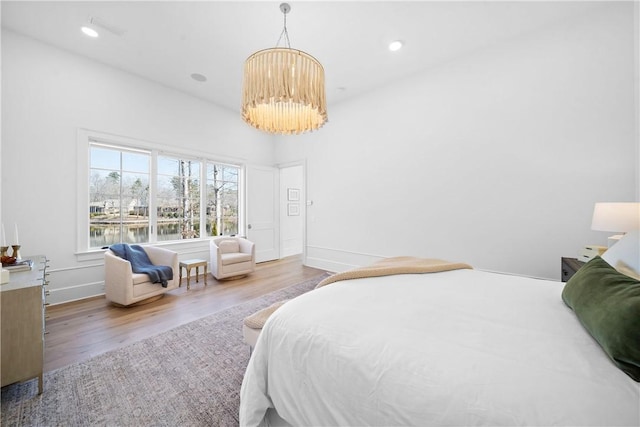 bedroom with baseboards, a chandelier, wood finished floors, and recessed lighting