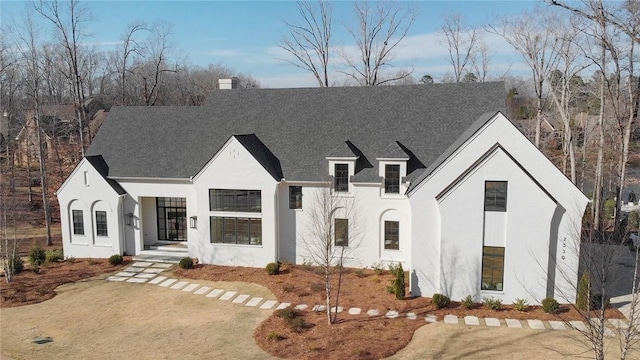 view of front facade featuring a chimney and stucco siding