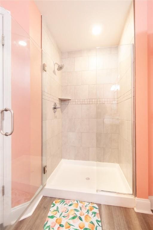 bathroom with wood-type flooring and a shower with door