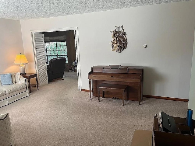 miscellaneous room featuring a textured ceiling and light carpet