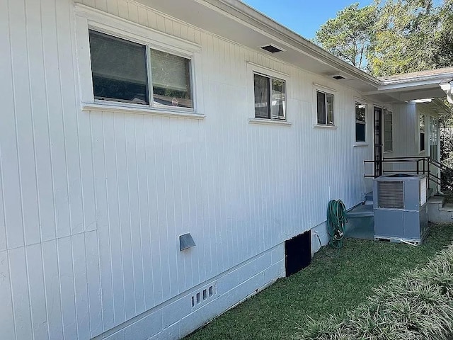 view of home's exterior with central AC unit and a lawn