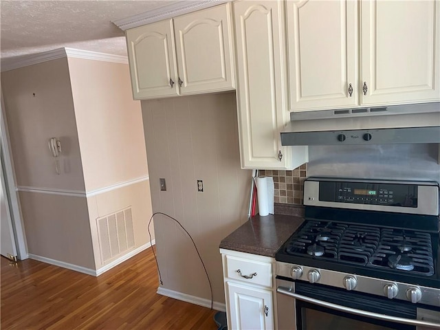 kitchen featuring stainless steel gas stove, white cabinetry, and a textured ceiling