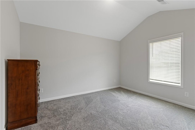 spare room with carpet flooring and lofted ceiling