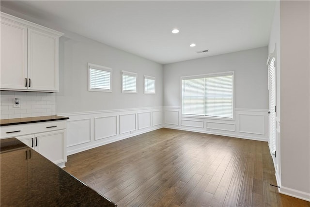 unfurnished dining area with dark wood-type flooring