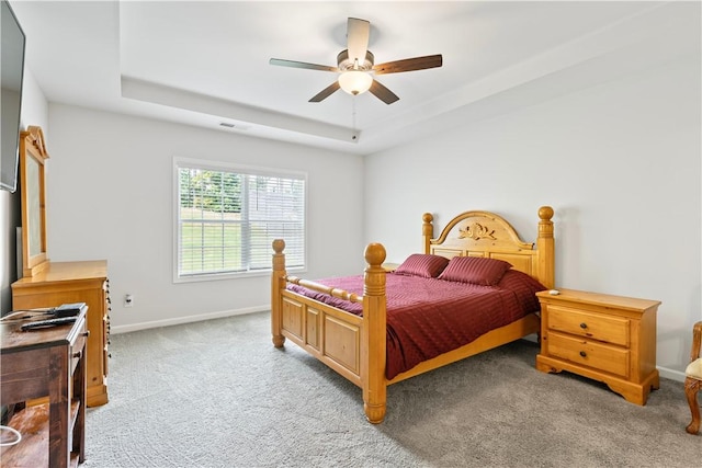 bedroom featuring a tray ceiling, ceiling fan, and light colored carpet