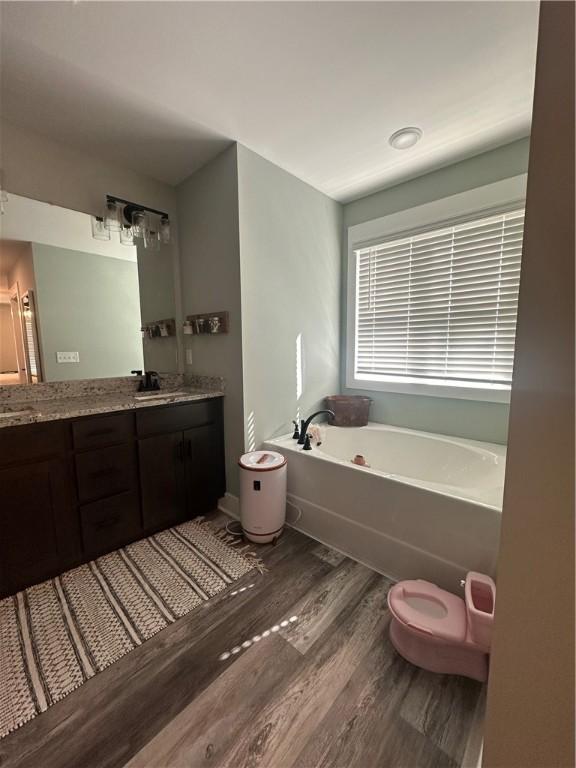 301 Lee Road 994, Cusseta, AL 36852 - bathroom with double vanity, a sink, a garden tub, and wood finished floors