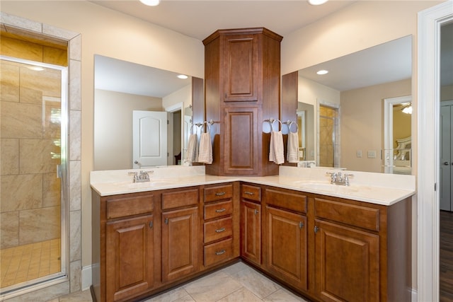 full bath featuring double vanity, a shower stall, and a sink