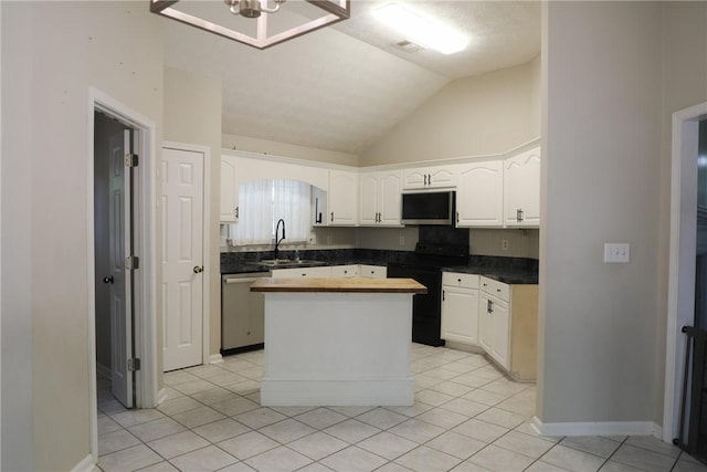 106 Pine Ridge Ln, Tallassee, AL 36078 - kitchen with stainless steel appliances, vaulted ceiling, white cabinetry, light tile patterned floors, and a center island