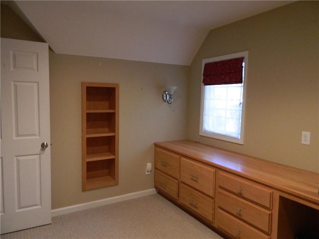 unfurnished bedroom featuring lofted ceiling and light carpet