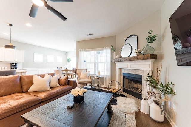 living area with a fireplace, recessed lighting, visible vents, a ceiling fan, and wood finished floors