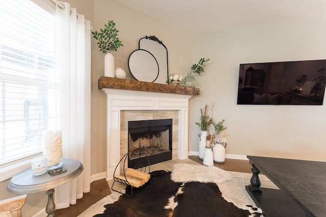 sitting room featuring baseboards, a healthy amount of sunlight, and a tiled fireplace