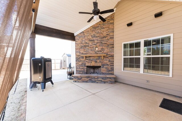 view of patio / terrace featuring an outdoor stone fireplace and ceiling fan