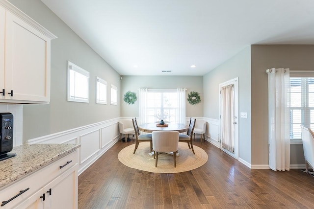 dining room featuring visible vents, wainscoting, dark wood-style flooring, a decorative wall, and recessed lighting