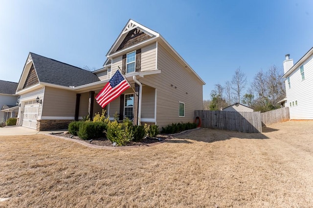 view of home's exterior with a yard, a shingled roof, an attached garage, and fence