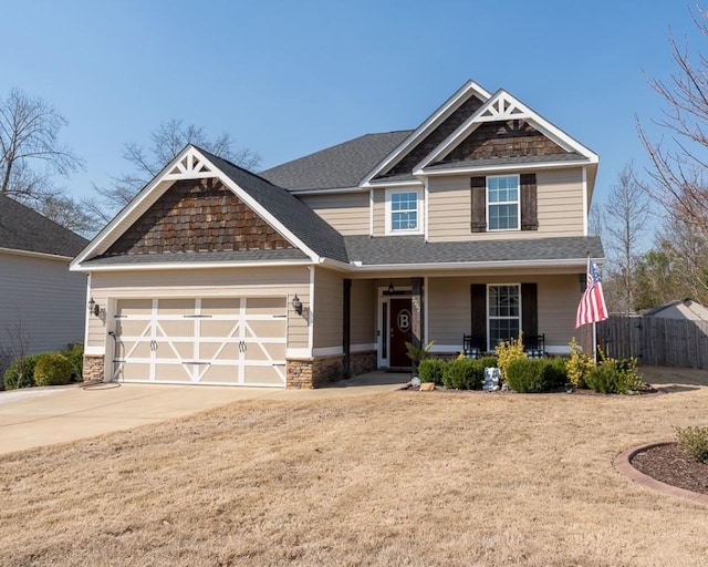 craftsman inspired home with fence, driveway, roof with shingles, an attached garage, and covered porch