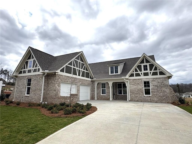 view of front of house with concrete driveway, brick siding, roof with shingles, and a front yard