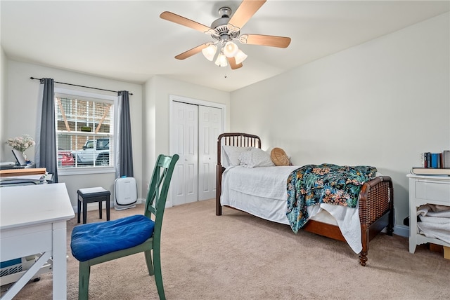 bedroom with ceiling fan, light carpet, and a closet