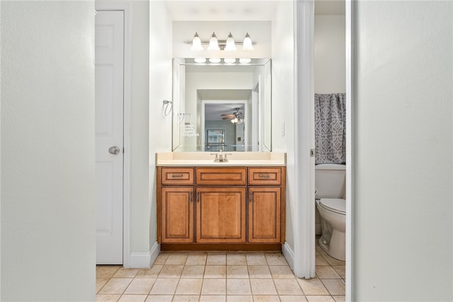 bathroom with vanity, baseboards, toilet, and tile patterned flooring