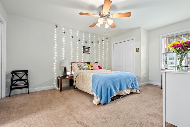 bedroom with light carpet, baseboards, a closet, and ceiling fan