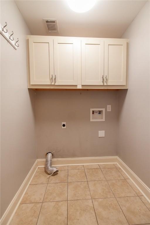 735 Hunter Ct, Auburn, AL 36832 - laundry area with cabinet space, hookup for an electric dryer, washer hookup, light tile patterned flooring, and baseboards