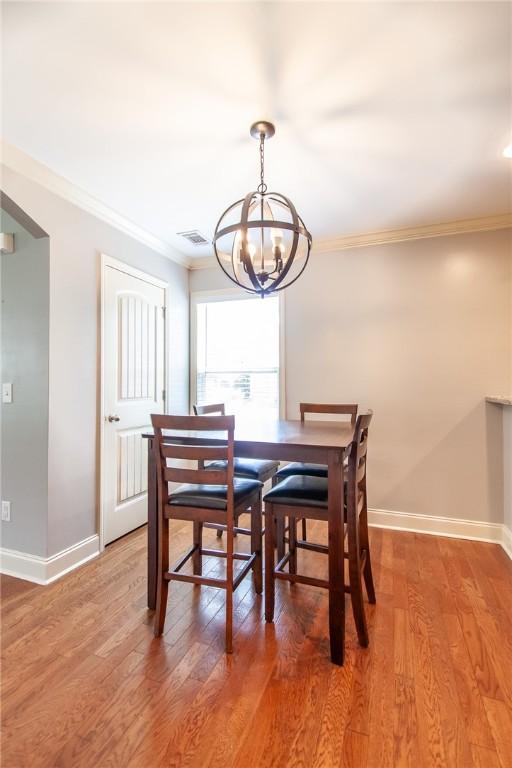 735 Hunter Ct, Auburn, AL 36832 - dining space with a chandelier, baseboards, ornamental molding, and light wood-style flooring