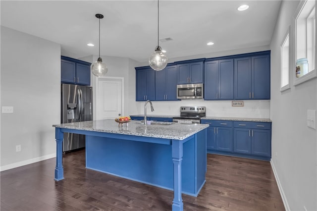 kitchen featuring light stone countertops, appliances with stainless steel finishes, a kitchen breakfast bar, a kitchen island with sink, and sink