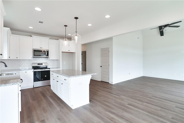 kitchen with a kitchen island, appliances with stainless steel finishes, sink, white cabinets, and hanging light fixtures