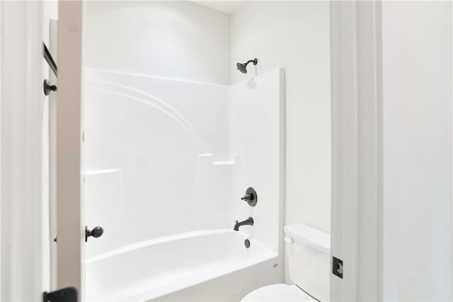 bathroom featuring shower / bathing tub combination and toilet