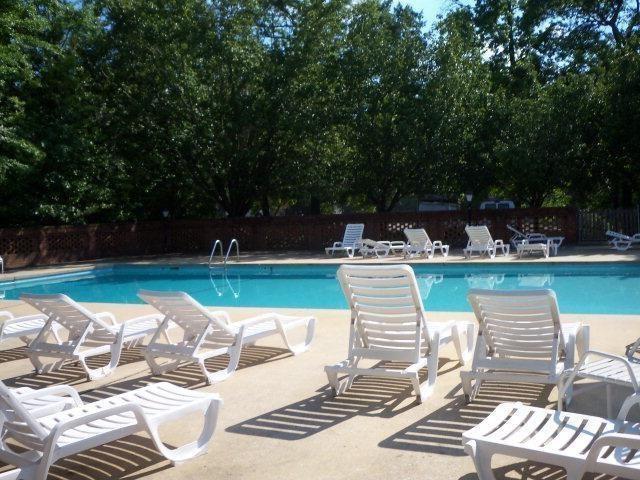 pool with a patio area and fence