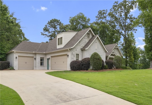 view of front of house with a garage, roof with shingles, driveway, and a front lawn