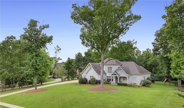 view of front of property with fence and a front lawn