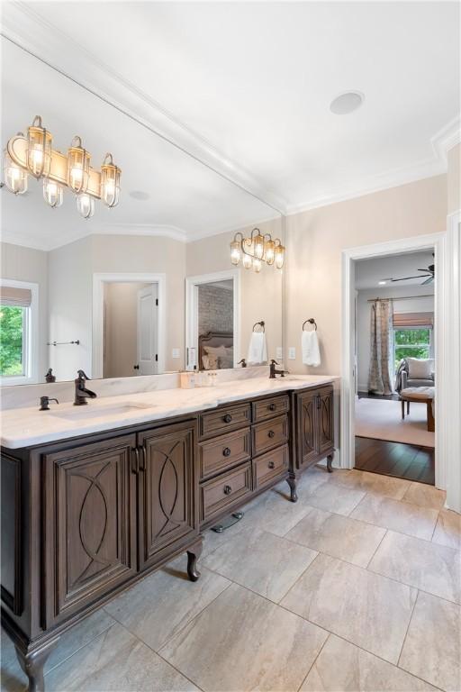 full bathroom featuring double vanity, plenty of natural light, ensuite bath, and crown molding