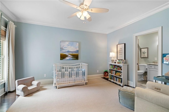 bedroom featuring crown molding, a crib, baseboards, and ceiling fan