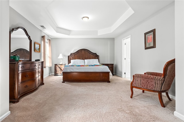 bedroom featuring carpet, visible vents, a raised ceiling, and baseboards