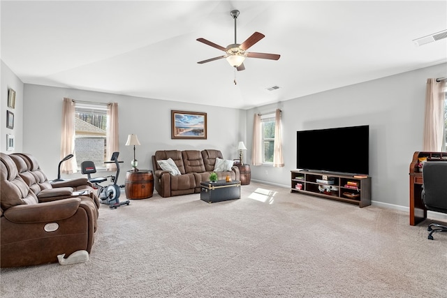 carpeted living area with a ceiling fan, visible vents, vaulted ceiling, and baseboards