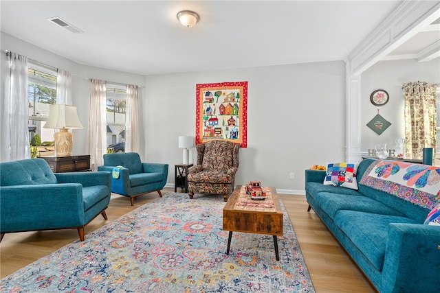 living room featuring visible vents, baseboards, and wood finished floors