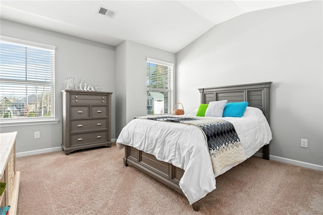 bedroom with visible vents, vaulted ceiling, light carpet, and multiple windows