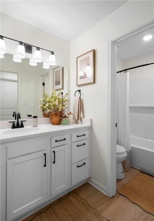 full bath featuring vanity, toilet, shower / bathtub combination with curtain, and wood finished floors