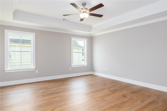 2022 Hidden Lakes Dr, Opelika, AL 36801 - empty room featuring a tray ceiling, light wood-style floors, ornamental molding, ceiling fan, and baseboards