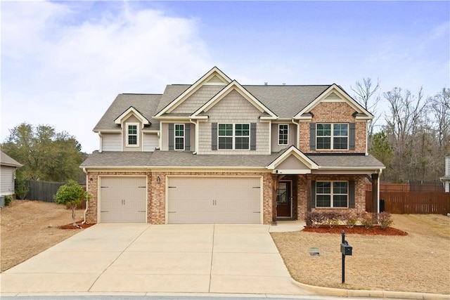 craftsman-style house with a garage, brick siding, and fence