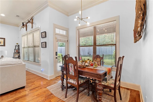 dining room with crown molding, plenty of natural light, and light wood-type flooring