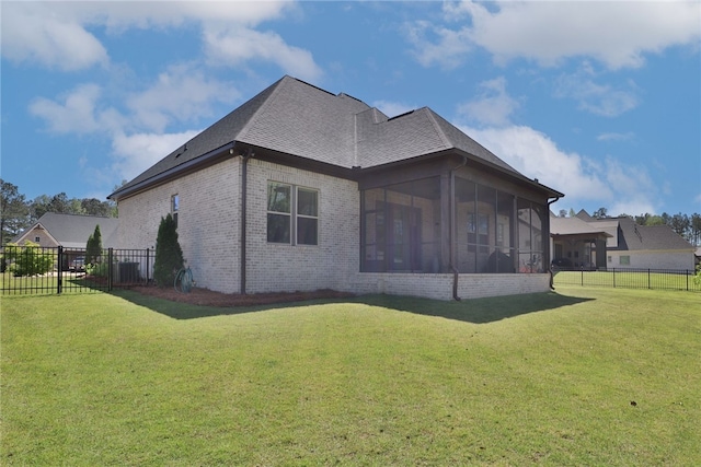 rear view of house with a lawn and a sunroom